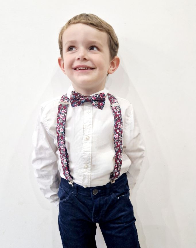 enfant qui porte des bretelles et un nœud papillon assortis 